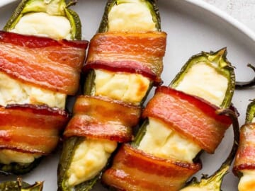 Bacon wrapped jalapenos on a plate.