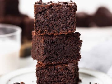 A stack of chocolate brownies on a plate.