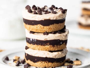 Peanut butter chocolate cheesecake cups stacked on a plate.