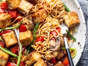 Tofu stir fry in a pan with vegetables and mushrooms.