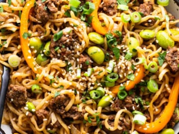 A bowl of noodles with meat and vegetables.