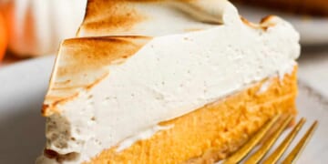 A slice of pumpkin pie on a plate with a fork.