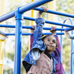 girl playing on playground monkey bars