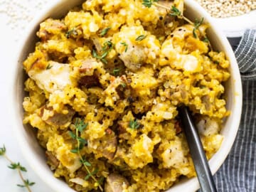 A bowl of rice with meat and thyme.