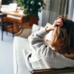 photo of woman with headache on sofa