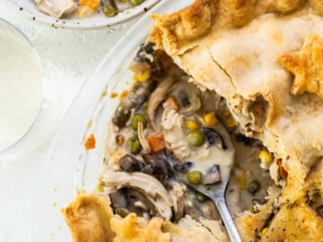 A chicken pot pie on a plate with a slice taken out.