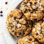 A plate of chocolate chip oatmeal cookies on a white plate.