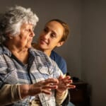 photo of woman comforting senior mother