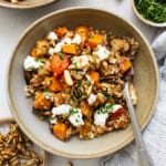 A bowl of quinoa and squash with feta and nuts.