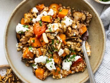 A bowl of quinoa and squash with feta and nuts.