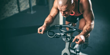 Man on stationary bicycle working hard.