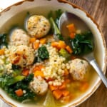 A bowl of Italian wedding soup with a spoon