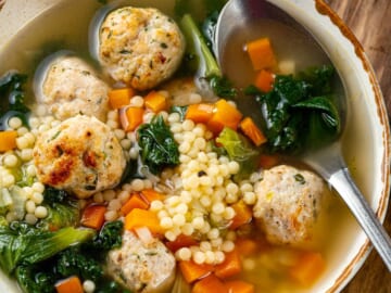 A bowl of Italian wedding soup with a spoon