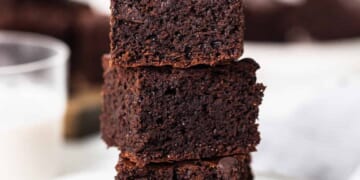 A stack of chocolate brownies on a plate.