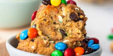 A bowl filled with cookies and m&m's.