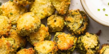 A plate of fried brussel sprouts with dipping sauce.