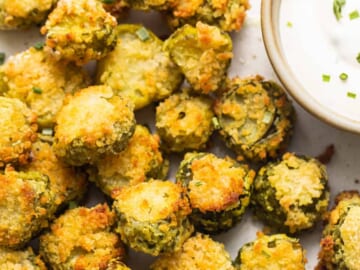 A plate of fried brussel sprouts with dipping sauce.