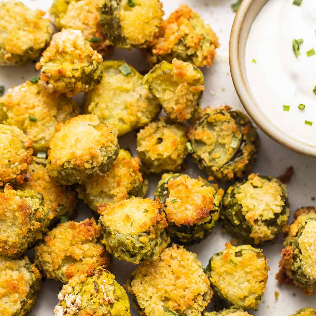 A plate of fried brussel sprouts with dipping sauce.