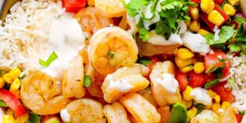 A white bowl with shrimp, rice and vegetables.