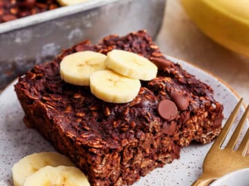 A plate of chocolate banana granola with banana slices on it.