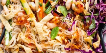 A bowl of asian noodle salad with shrimp and vegetables.