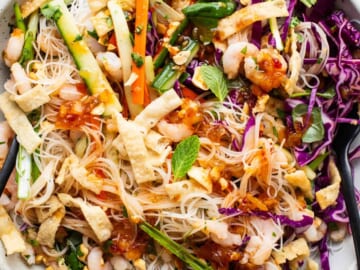 A bowl of asian noodle salad with shrimp and vegetables.
