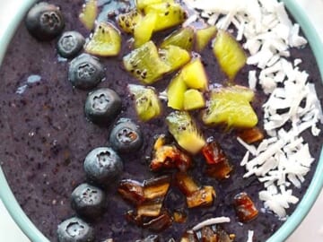 Blueberry Smoothie Bowl filled with blueberry, coconut, and kiwi smoothie.