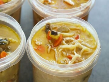 Four plastic containers filled with soup are frozen.