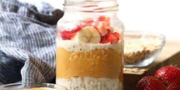 Overnight oats in a jar topped with peanut butter, strawberries and bananas.