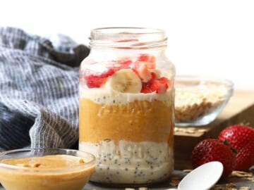 Overnight oats in a jar topped with peanut butter, strawberries and bananas.