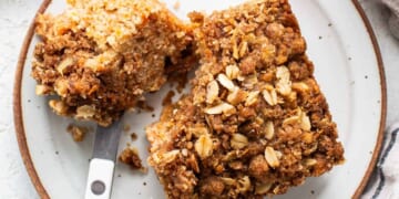 A slice of oatmeal coffee cake on a plate with a fork.