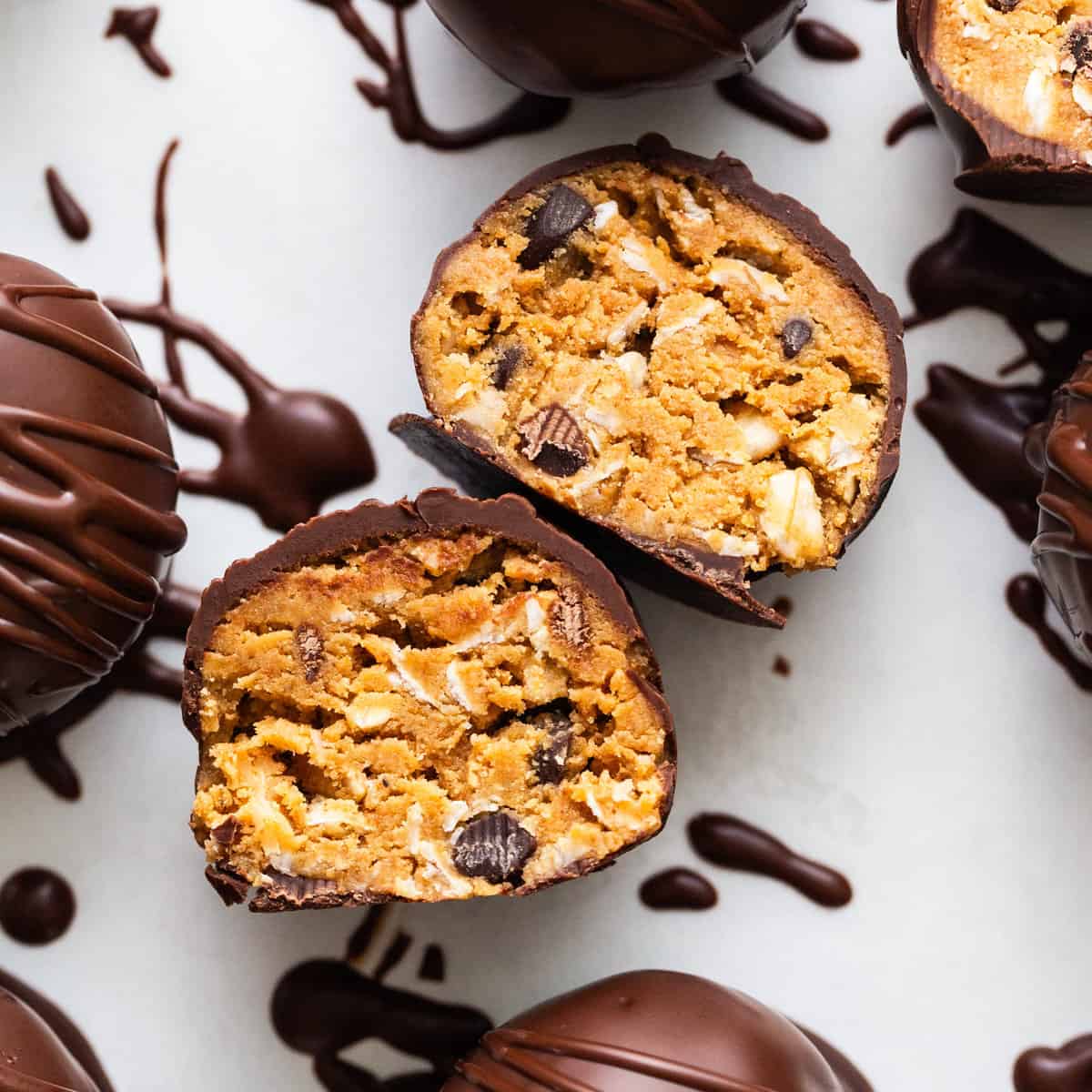 Chocolate covered peanut butter truffles on a white surface.