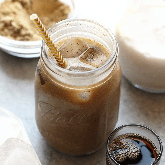 A jar of cold brew protein drink with a straw next to it.