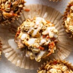 A group of muffins with granola and carrots.