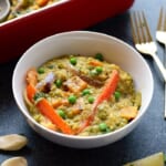 A white bowl with quinoa and vegetables.