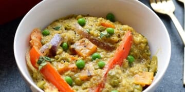 A white bowl with quinoa and vegetables.