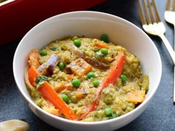 A white bowl with quinoa and vegetables.