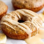 A banana-flavored donut with a glaze topping on a white background.