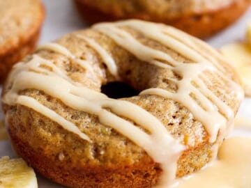 A banana-flavored donut with a glaze topping on a white background.