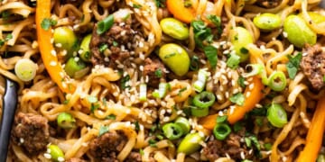 A bowl of noodles with meat and vegetables.