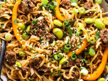 A bowl of noodles with meat and vegetables.