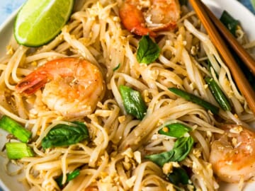 Pad Thai with shrimp on white plate with chopsticks