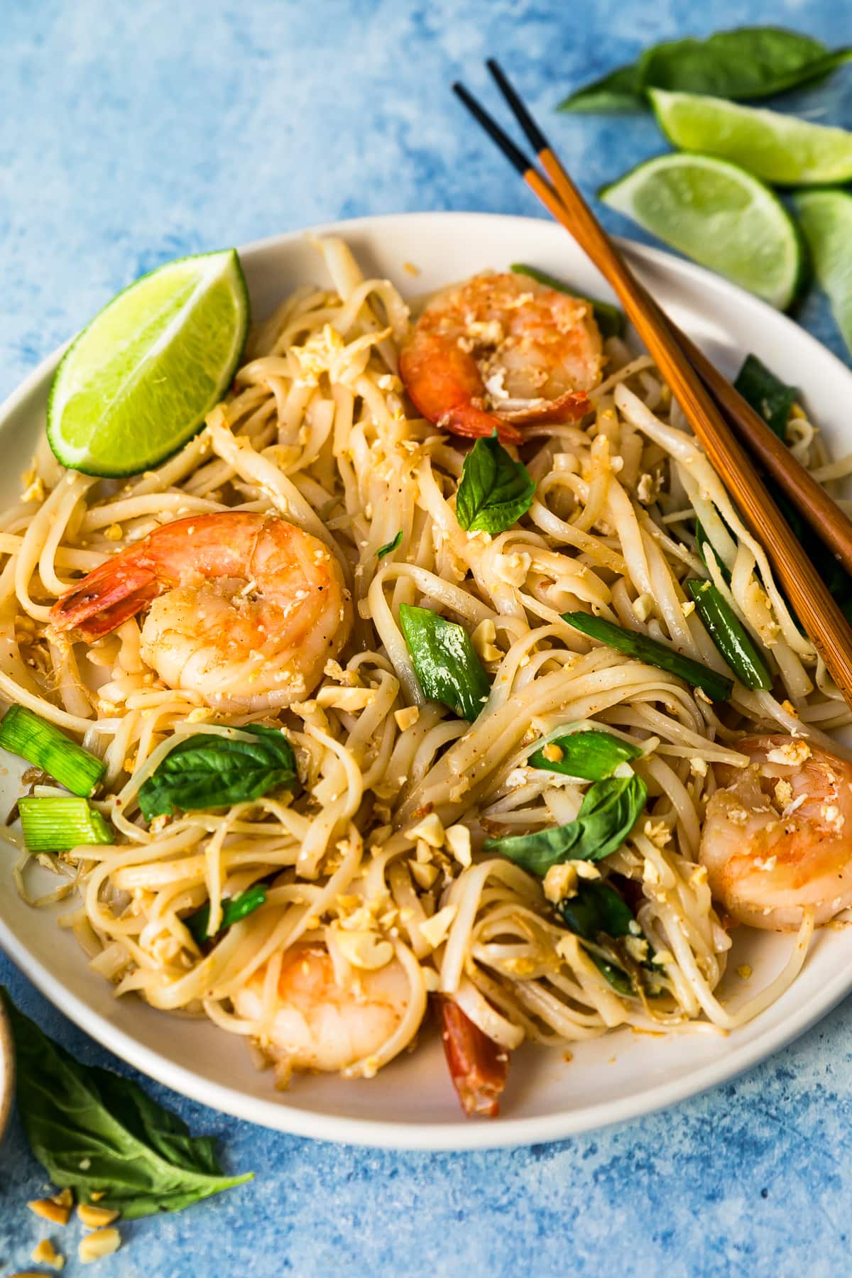 Pad Thai with shrimp on white plate with chopsticks